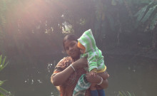 Abeda standing with her baby