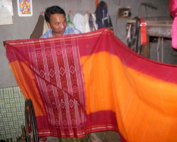 A weaver with a finished sari.