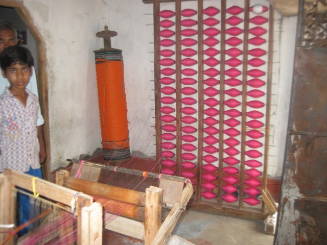 The thread yarn ready to be fed into the warping machinery. In the background, finished warp