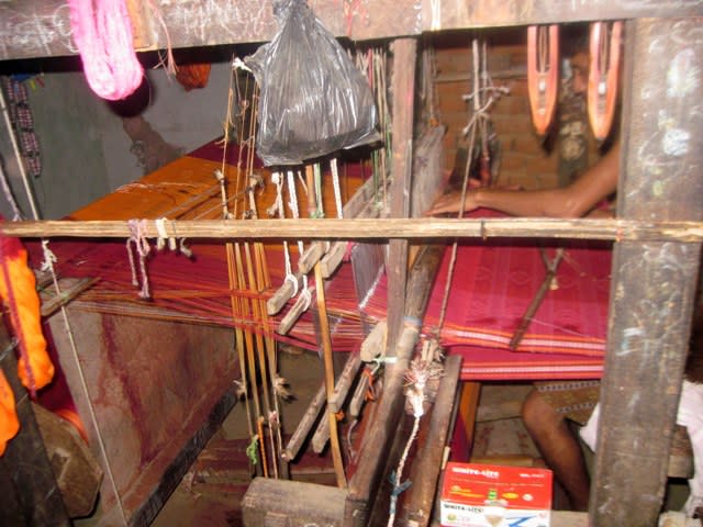 The raised warp ends passing through the heddles and the shed created is seen clearly in this picture.