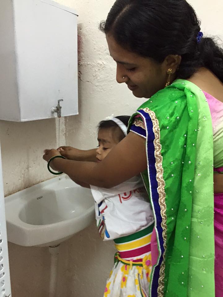 Teacher helping in handwash